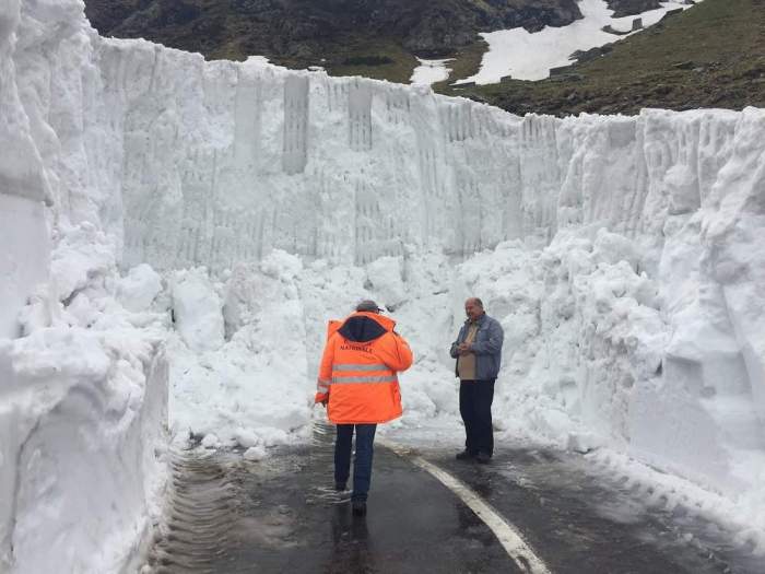 Doi bărbați în fața unui ”perete” de zăpadă
