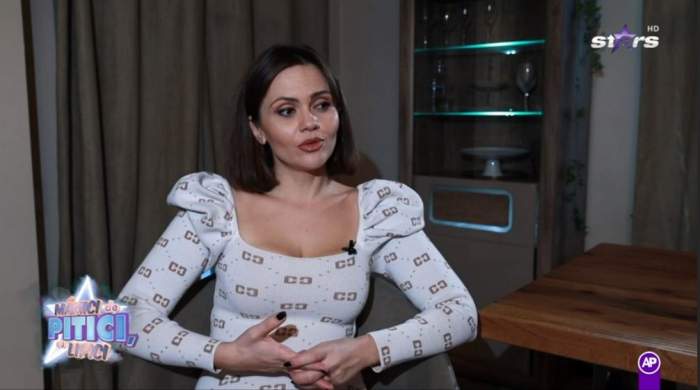 Cristina Siscanu este la interviu la Mamici de pitici, cu lipici, poarta o bluza alba cu decolteu si are parul desprins