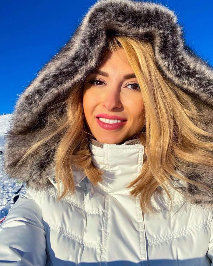 Andreea Bălan într-un selfie. Artista poartă o haină de iarnă albă și are gluga pe cap.