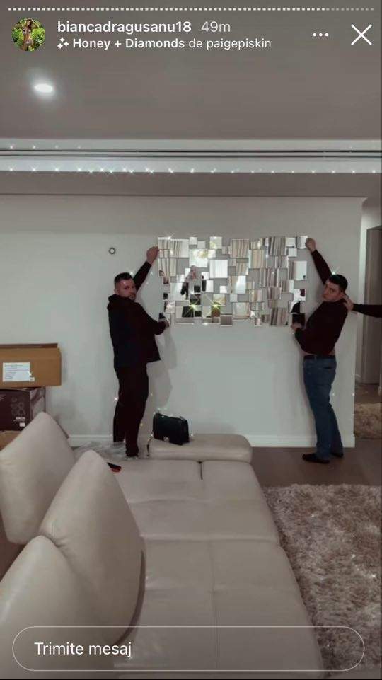 Doi oameni pun mai multe oglinzi pe perețeii apartamentului Biancăi Drăgușanu