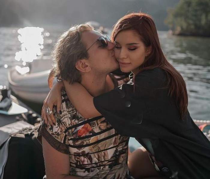 Carmen Grebenișan și iubitul ei se află pe o barcă. El poartă un tricou înflorat și o sărută pe obraz, iar ea îl ține de gât și e îmbrăcată cu un tricou negru.