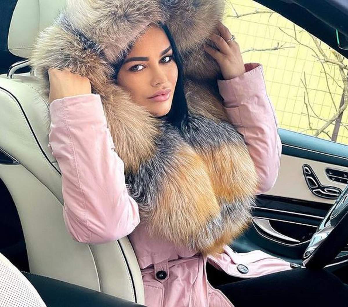 Carmen de la Sălciua se află în mașină. Vedeta poartă o haină de iarnă roz și își ține gluga pe cap.
