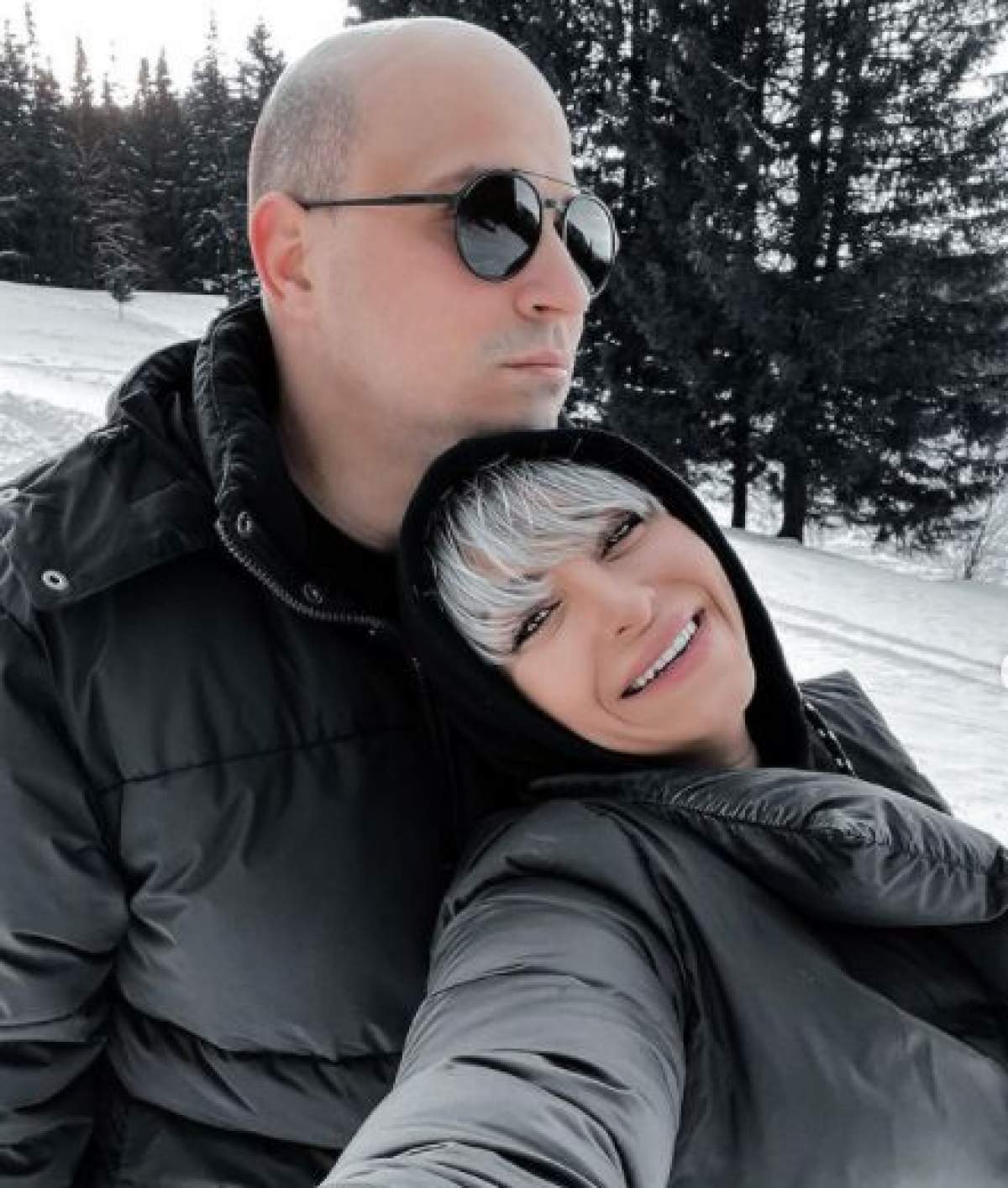 Vlad Huidu și Giulia Anghelescu, îmbrăcați în negru, îmbrățișați la munte