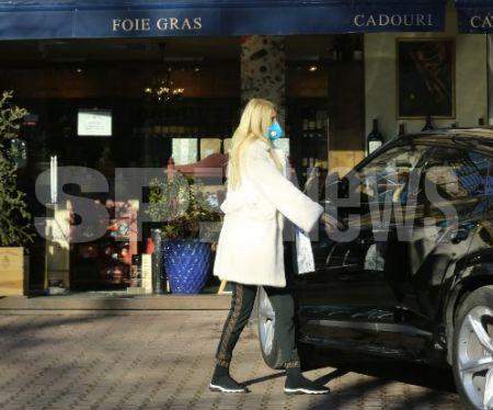 Maya Marcu, în ținută alb-negru, urcându-se în mașina sa de lux. Imagine surprinsă de paparazzii SpyNews.ro