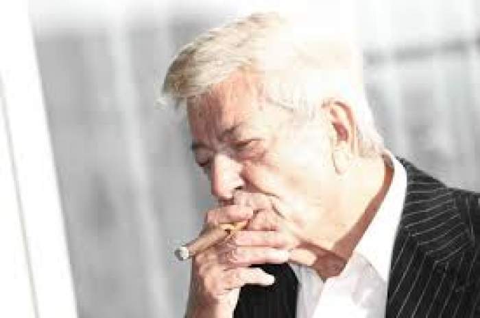 Ion Dichiseanu, fumează trabuc, în cămașă albă și sacou negru