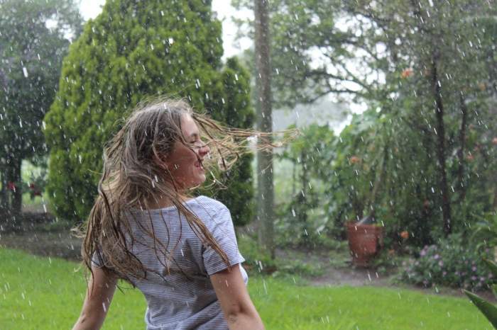 o fata care se bucura de ploaie