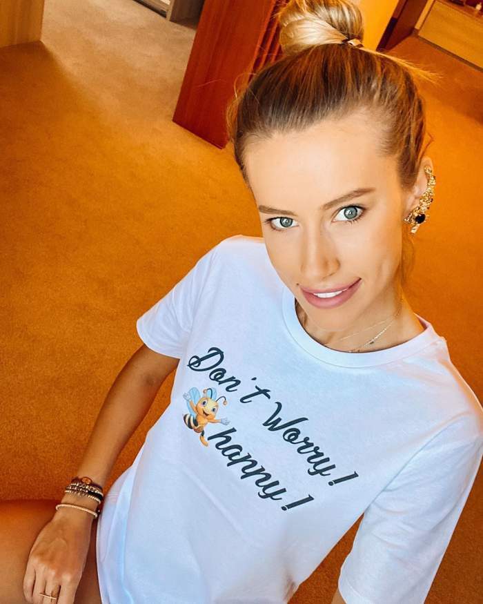 Gabriela Prisacariu, selfie acasă, în tricou alb, cu părul prins în coc și zâmbitoare