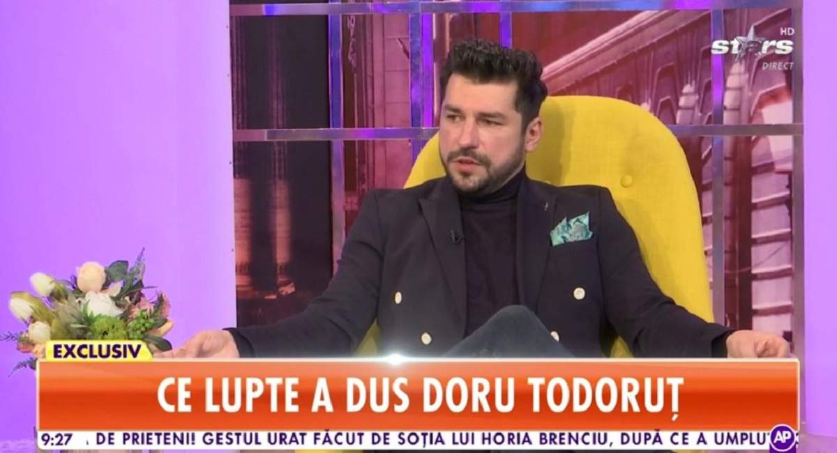 Doru Todoruț stă pe un fotoliu galben. Artistul oferă un interviu la „Antena Stars”.