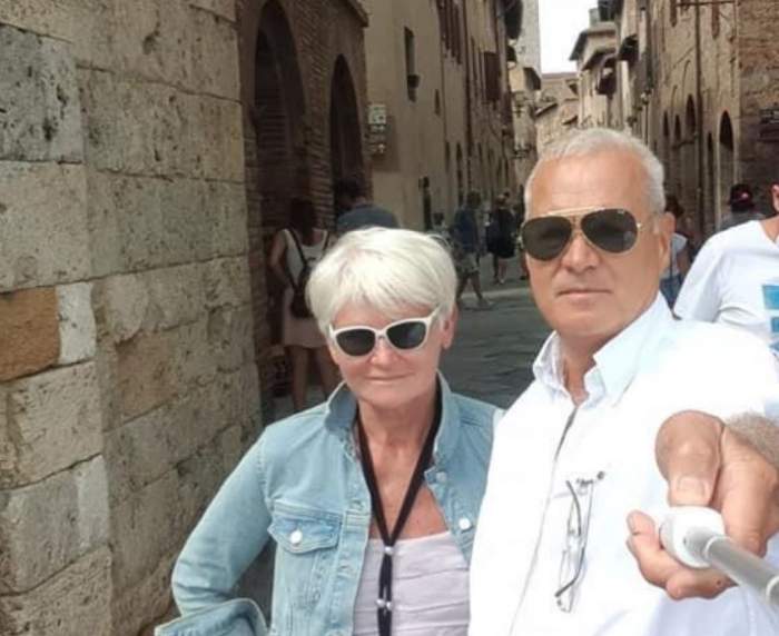 Monica Tatoiu și soțul ei în vacanță. Ea poartă o cămașă bleu, descheiată, iar el o cămașp albă.