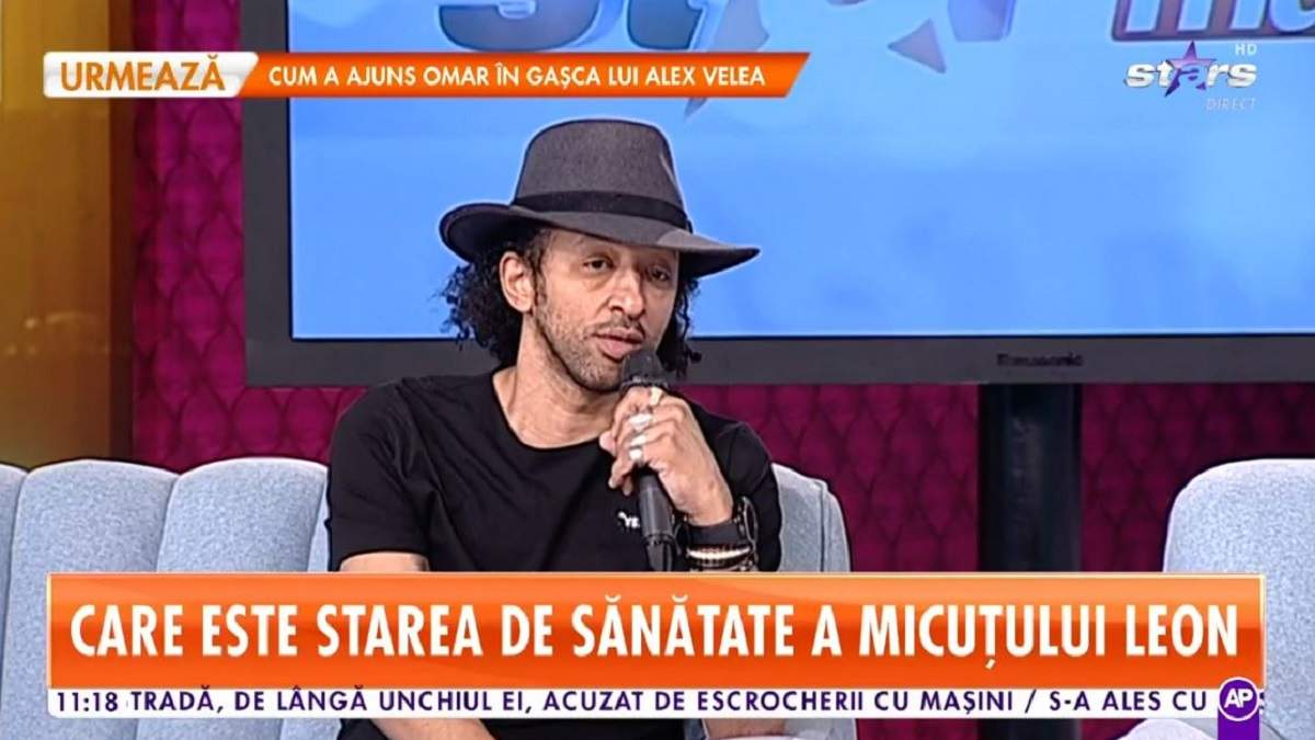 Kamara se află pe canapeaua de la Star Matinal. Artistul vorbește la microfon și poartă o pălărie gri pe cap. Cântărețul e îmbrăcat cu un tricou negru.