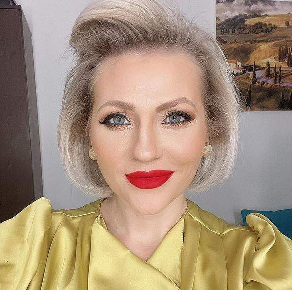 Mirela Vaida într-un selfie. Vedeta poartă o bluză galbenă și e dată cu ruj roșu pe buze.