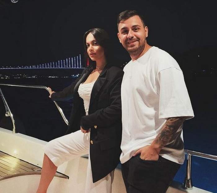 Betty și Cătălin Vișănescu se află pe un vapor, în vacanță. Artista poartă un sacou negru și pantaloni albi, iar el un tricou alb și niște blugi negri.
