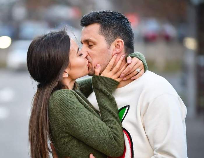 Denisa Hodișan și Flick se sărută în public. El poartă un pulover alb, iar ea unul verde.