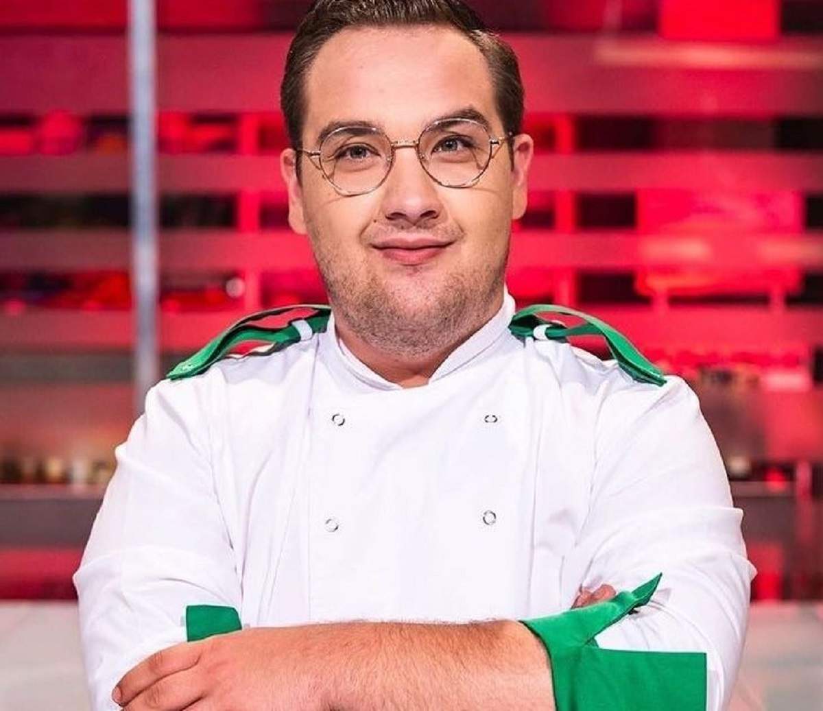 Răzvan Babană este la Chefi la cuțite. Fostul concurent ține mâinile în sân și poartă uniformă de bucătar albă, cu mâneci și umeri verzi.