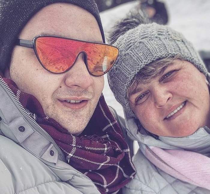 Răzvan Babană și mama lui într-un selfie. Ea poartă o geacă de iarnă și un fes gri, iar el geacă de iarnă gri și un fes negru. Amândoi zâmbesc larg.