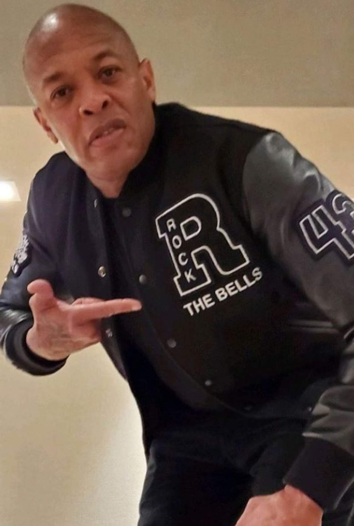 Dr.Dre poarta o jacheta neagra si arata cu degetul spre ea