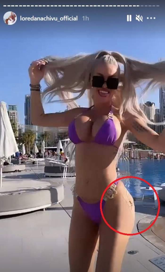 Loredana Chivu se află pe plajă, în Dubai. Vedeta poartă un costum de baie mov.