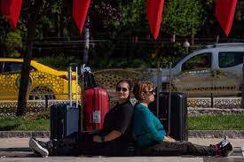 Adriana Trandafir și Maria Speranța stau lângă geamantane