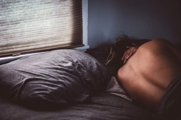 femeie cu spatele gol în pat