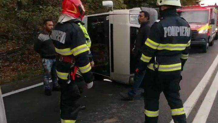 Pompieri și martori lângă microbuzul răsturnat