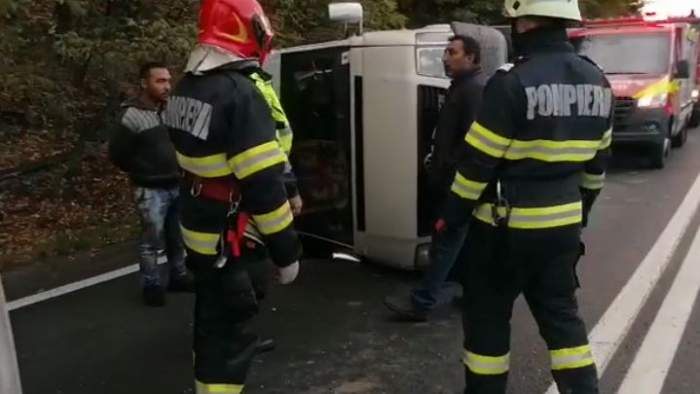 Pompieri și martori lângă microbuzul răsturnat
