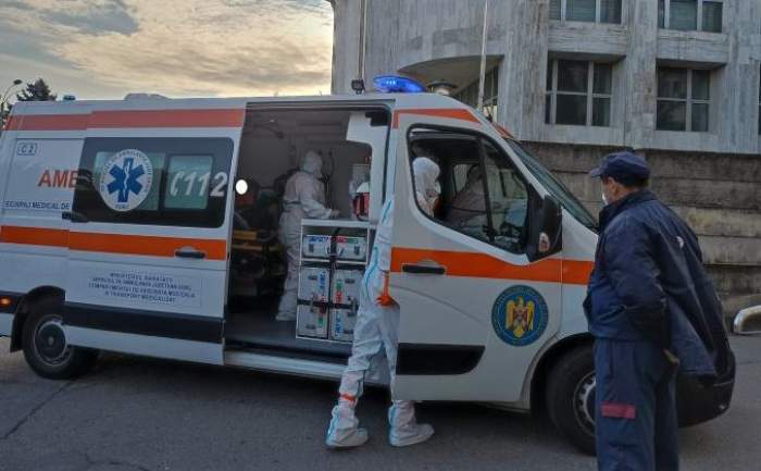 Medic lângă o ambulanță și un paznic în apropiere