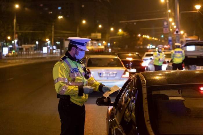 Un polițist verifică un șofer noaptea