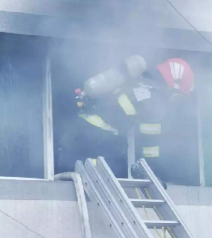 Un pompier care iese pe geam