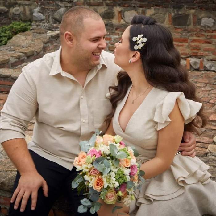 Alexandru Bădițoaia și soția, îmbrățișați, mimând un pupic