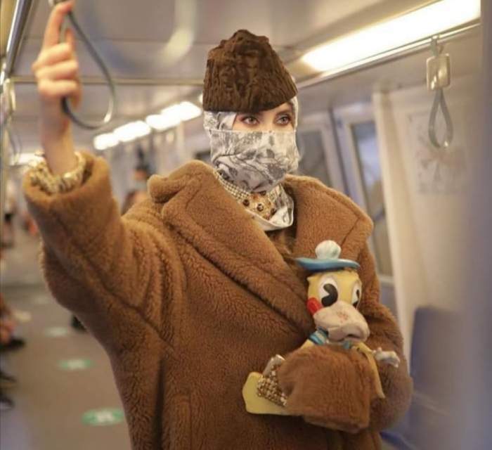 Iulia ALbu, în metrou, cu o păpușă în mână