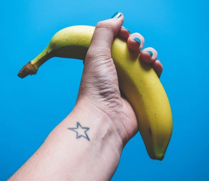 o mână care ține o banană