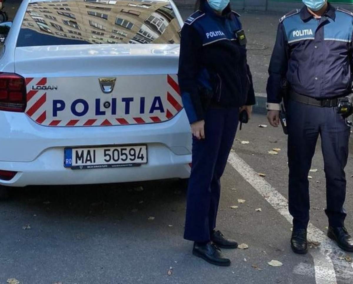 polițiști lângă mașina de poliție