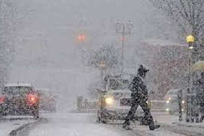 Un bărbat în trafic, prin zăpadă