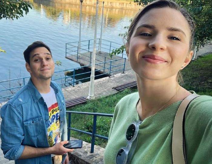 Cristina Ciobănașu și Vlad Gherman se află în parc. Ea poartă o bluză verde, iar el un tricou alb și o cămașă din denim.