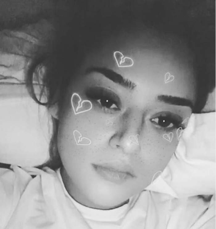 Fosta soție a lui What's Up într-o fotografie alb-negru. Blondina se alfă în pat și are pe față un filtru de pe Snapchat cu inimioare.