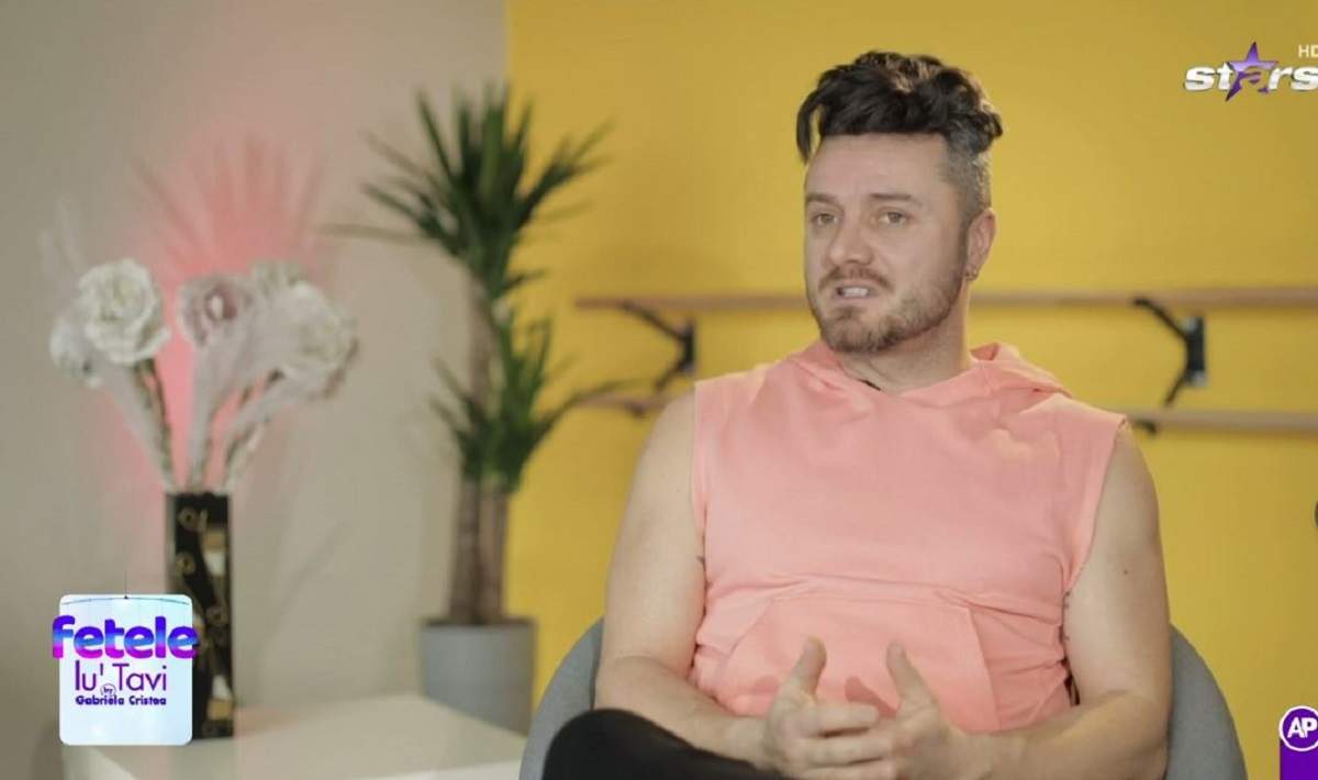 Tavi Clonda dă un interviu la Antena Stars. Artistul poartă un hanorac fără mâneci de culoare roz.