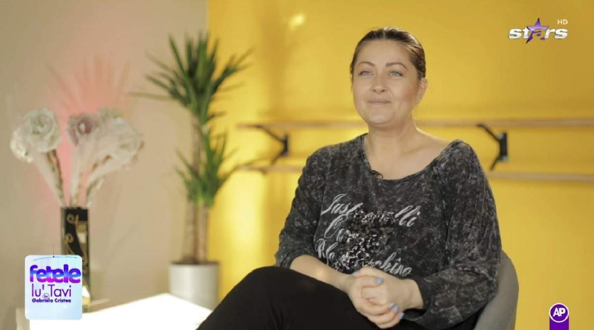 Gabriela Cristea dă un interviu pentru Antena Stars. Vedeta poartă o bluză neagră și o pereche de colanți negri.