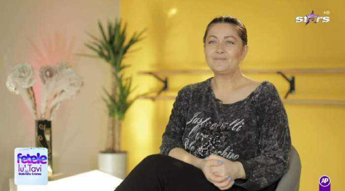 Gabriela Cristea dă un interviu pentru Antena Stars. Vedeta poartă o bluză neagră și o pereche de colanți negri.