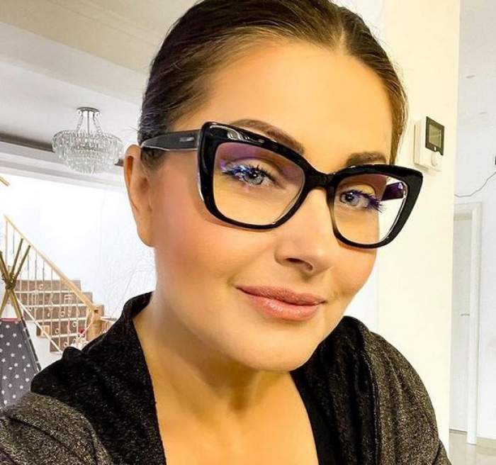 Gabriela Cristea își face un selfie. Vedeta poartă ochelari de vedere și o bluză gri cu negru.