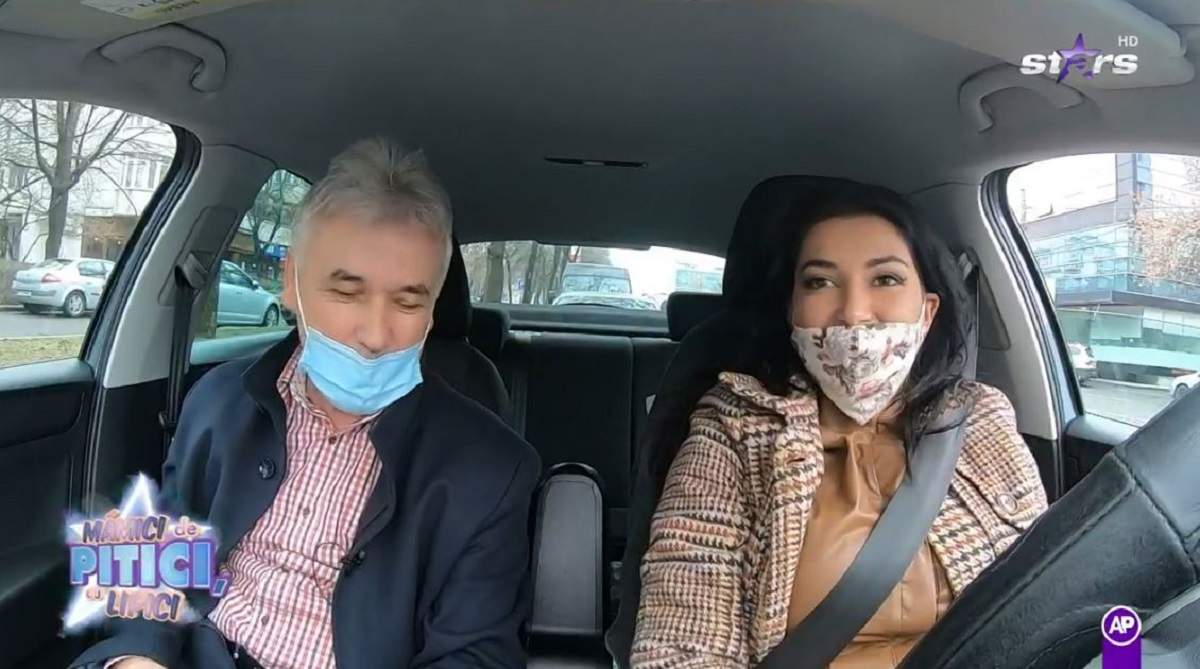 Elena Ionescu se află în mașină alături de instructorul ei auto. Cei doi partă mască de protecție. Artista poartă o rochie din piele maro, iar pe deasupra un sacou în aceleași nuanțe.