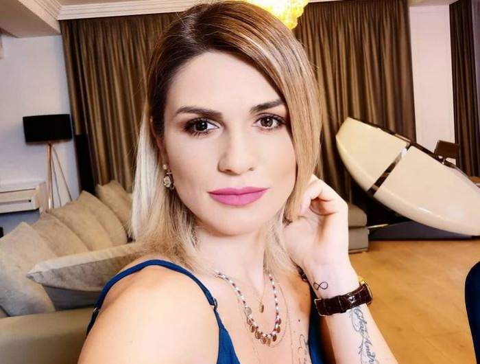 Ellie White e îmbrăcată într-un maiou albastru. Cântăreața își ține o mână prin păr.