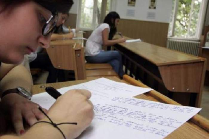 Un copil care scrie pe foaia de examen