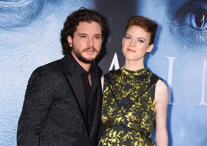 Kit Harington şi Rose Leslie din „Game of Thrones” la un eveniment pe covorul roșu. Ea poartă o rochie verde, înflorată, iar el un costum negru.