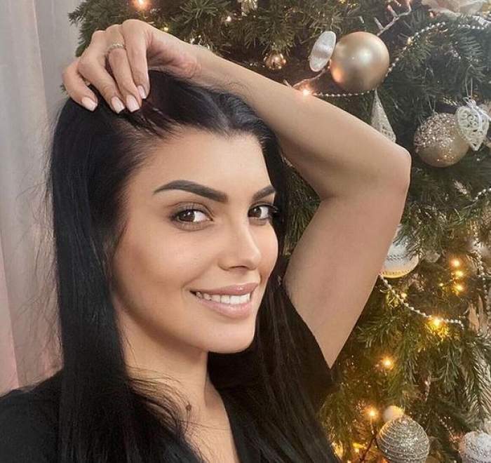 Andreea Tonciu își face un selfie. Vedeta poartă un tricou negru și zâmbește. În spatele ei se vede bradul de Crăciun.