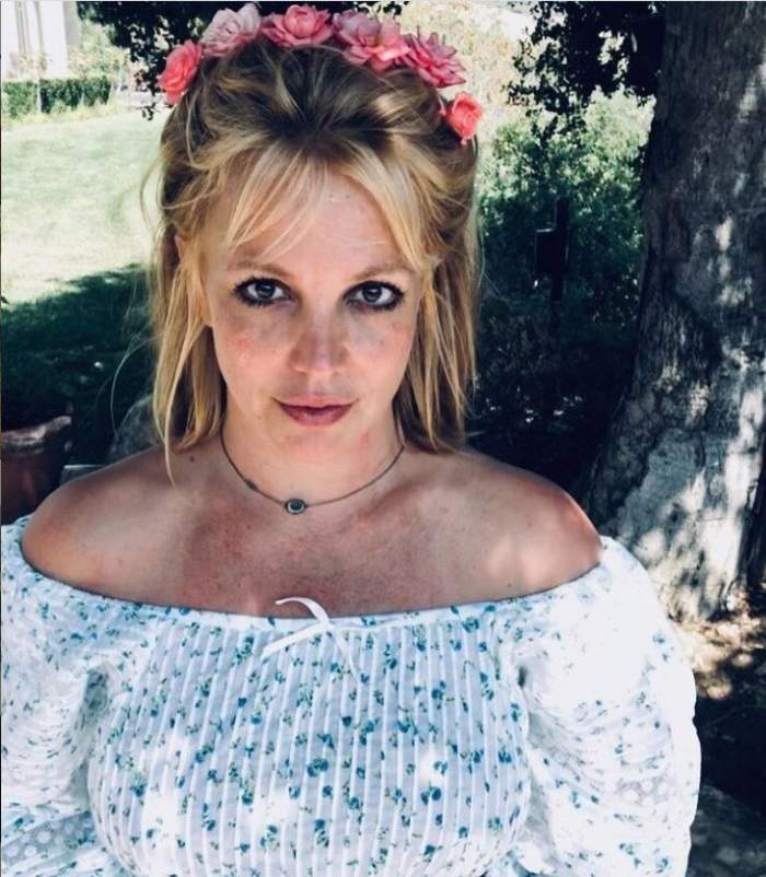 Britney Spears este in gradina, poarta o bluza fara umeri si o coronita cu flori pe cap