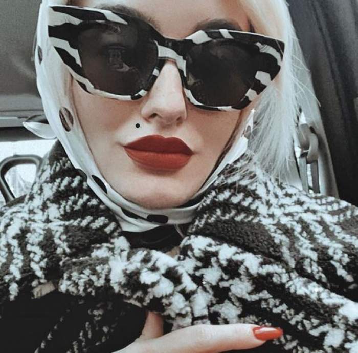 Ana Morodan este în mașină. Vedeta poartă o pereche de ochelari de soare și o haină de iarnă în alb și negru și pe cap o eșarfă albă cu buline negre.