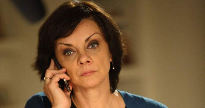 Carmen Tănase, îmbrăcată în albastru, vorbște la telefon
