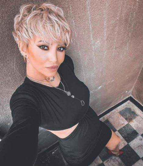 Giulia Anghelescu îmbrăcată în negru și cu părul scurt, blond.