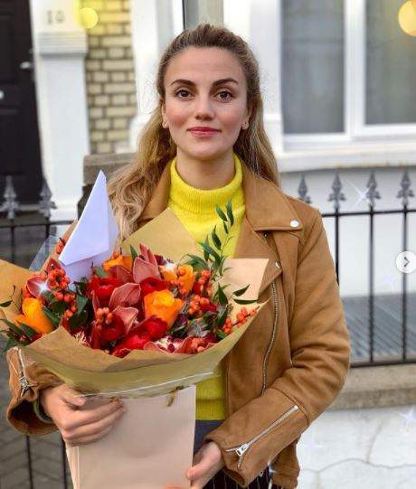 Selena cu un buchet de flori în brațe.