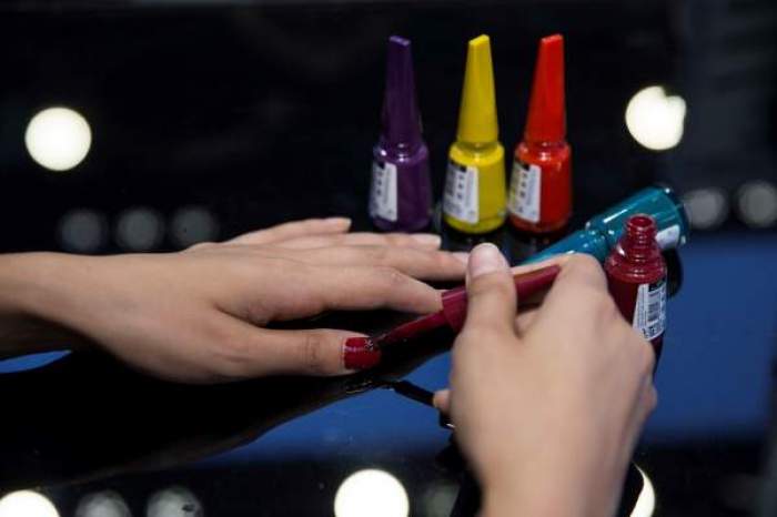O femeie își face unghii cu culori diferite